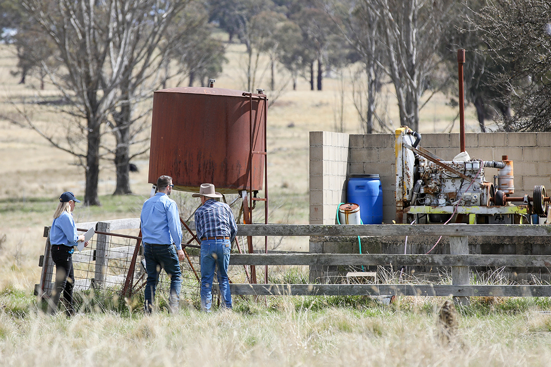 Two NRAR staff head over to inspect a pump with a farmer
