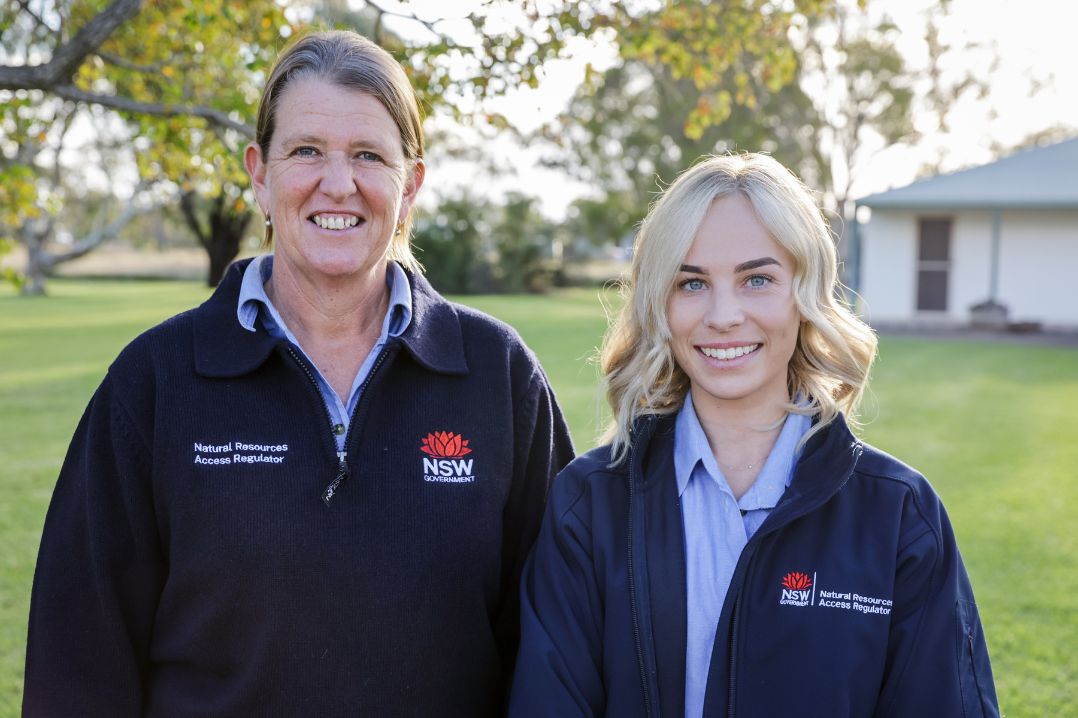 Two NRAR staff members in uniform with the NSW government logo and NRAR agency name visible on their clothing.