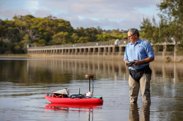 NRAR Technology Specialist operates the acoustic profiler boat on a dam